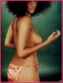 Tyra Banks posing topless with big afro
